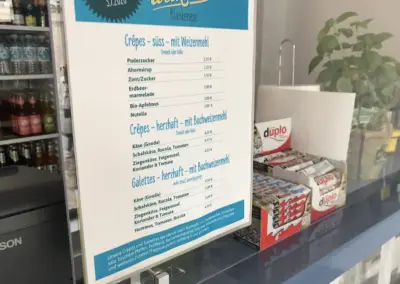 Die Ladentheke der Crêperie. Neben den Produkten sieht man die wunderschön gestaltete Speisekarte des Weekender Blankenese.